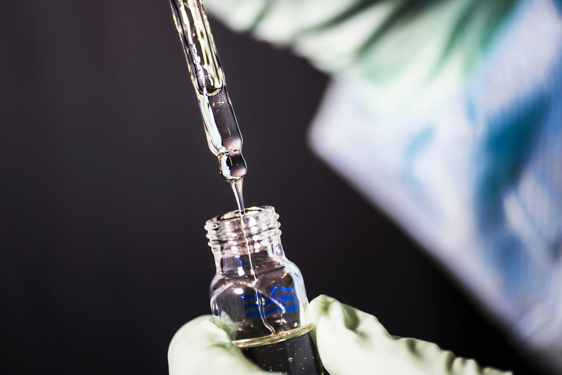 A pipette filling a vial in a laboratory