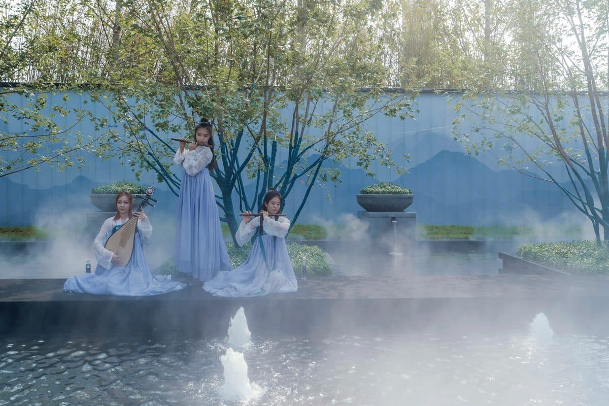 Performers in traditional dress within the mist garden